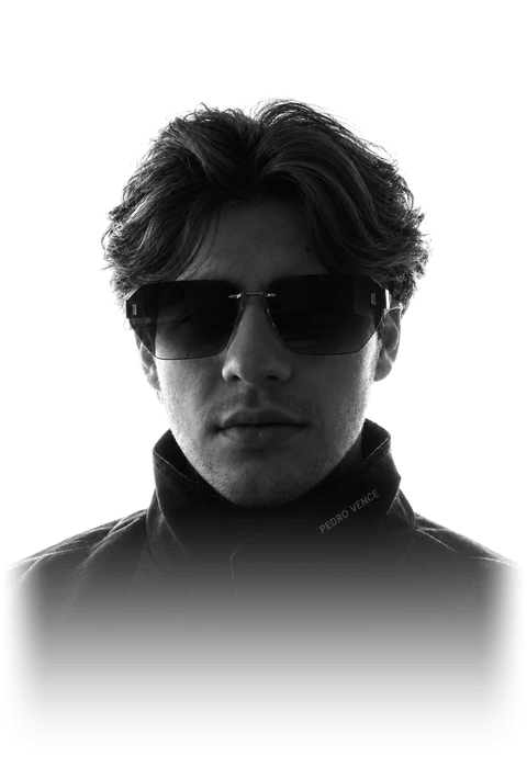 Retrato em preto e branco de Pedro Vence, de óculos escuros e jaqueta preta com o nome bordado na gola